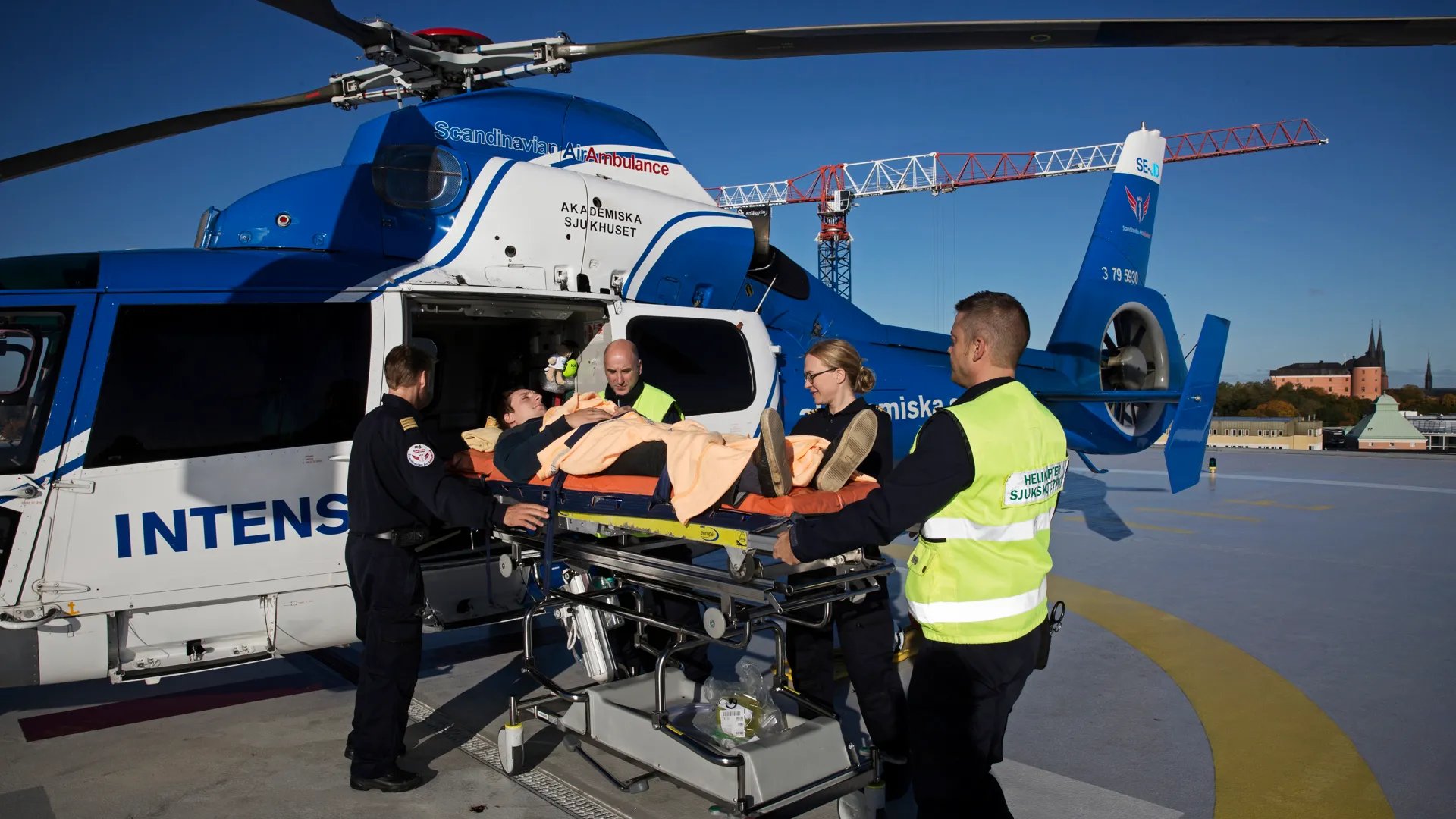 En grupp människor framför en helikopter.